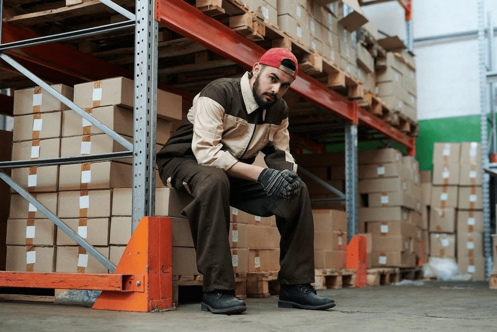 warehouse worker sitting on some boxes